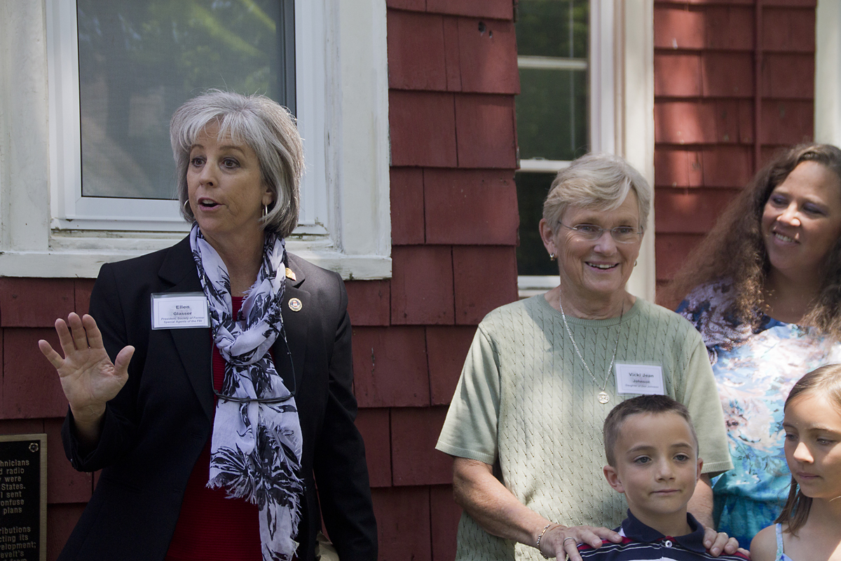 Ellen Glasser, president of the Society of Former Special Agents of the FBI (left), speaks about the Benson House as Vicki Jean Johnson, the daughter of one of the WWII agents (center) watches on. (Credit: Paul Squire)