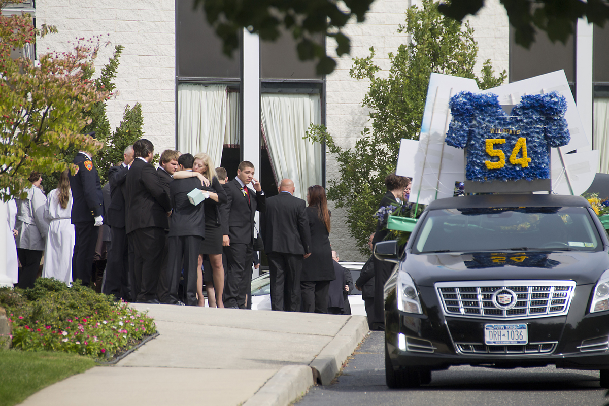 Tom Cutinella's family embrace after the teen's funeral Tuesday morning. The 16-year-old was killed after being injured while playing football last week.