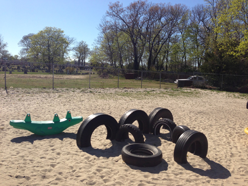 PAUL SQUIRE PHOTO | A man jumped over this section of fence into a daycare playground Tuesday afternoon. A Riverhead police car is parked in the background.