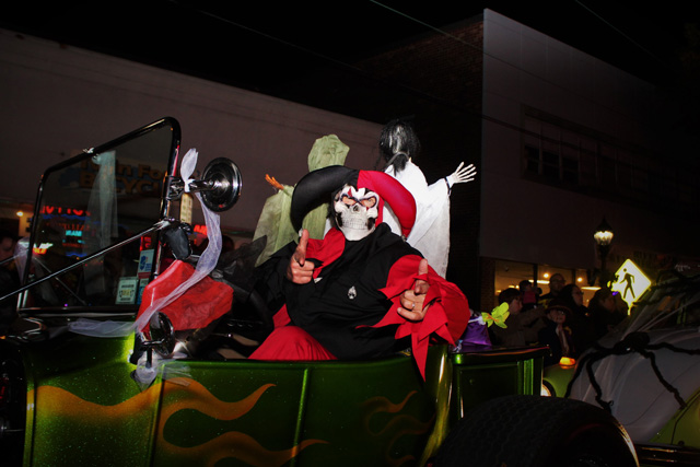 A crazed jester pauses to shoot finger guns at the camera.