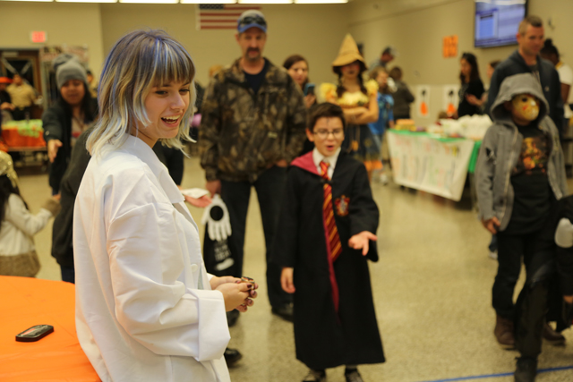 Riverhead High School junior and Key Club president Sarah Brennan watches as 'Harry Potter' knocks over pins in one of the Safe Halloween events.