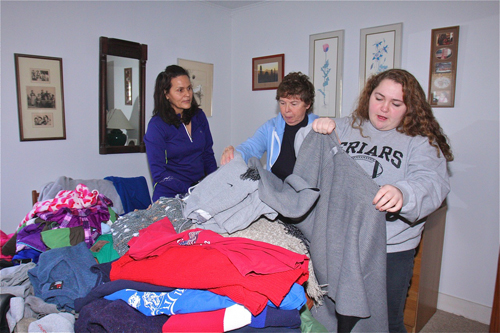 BARBARAELLEN KOCH PHOTO | Nir Silva of Hampton Bays (from left), Virginia Lemmers and Nina Keller, both of South Jamesport, sort through the donated Items in Ms. DeVito's bedroom Saturday afternoon.