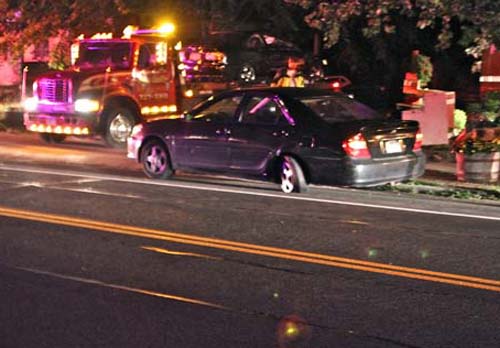 DWI_crash_illegal JENNIFER GUSTAVSON PHOTO | Oscar Aragon's Honda Civic gets transported from Main Road in Aquebogue Thursday night on a flatbed truck. The car he struck, owned by a St. James man, was towed from the scene.