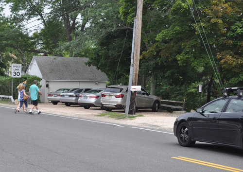 A couple crosses W. Main St. on Monday afternoon in front of Farm Country Kitchen. (Credit: Joseph Pinciaro)
