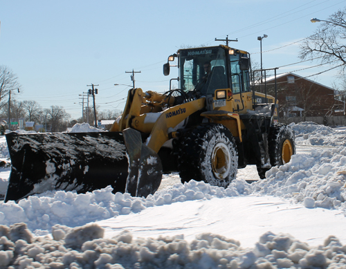 PAUL SQUIRE PHOTO | A bulldozer clears snow near the Flanders traffic circle Sunday morning.