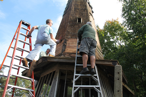 PAUL SQUIRE PHOTO | Volunteers with the community advocacy group Save Main Road work on restoring the Witch's Hat in Aquebogue Saturday afternoon.