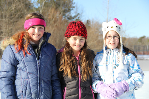 CARRIE MILLER PHOTO | At Stotzky Park's new ice rink Saturday, three friends from Baiting Hollow tried out their skating skills.