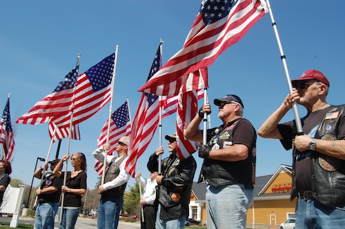 Members of the Patriot Guard Riders hold flags during Monday's press conference.
