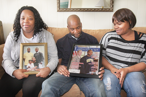 BARBARAELLEN KOCH PHOTO | Demitri Hampton's sister Jennifer Davis (left), brother Jamal Davis and first cousin Latisha Diego with photos of Demitri, who appeared on the cover of a Suffolk Community College campus magazine in 2012, during a meeting with reporters in Polish Town Tuesday.