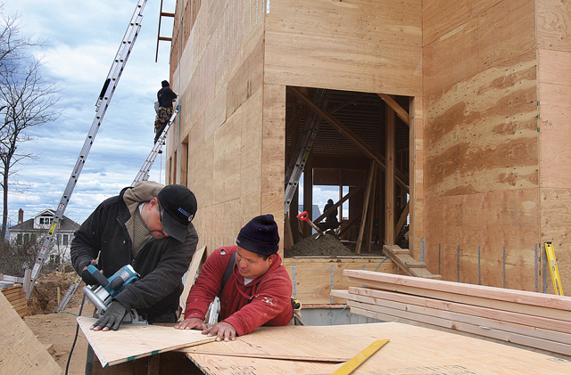 Carpenter Ruben Gonzales (left) of Hampton Bays works with carpenter assistant Henry Farec of Southampton on a house under construction on Sound Shore Road in Northville Monday afternoon. The house is being built by AP Construction Services LLC of Aquebogue for its owner Andrew Przepiorowski and his fiancée. (Credit: Barbaraellen Koch)