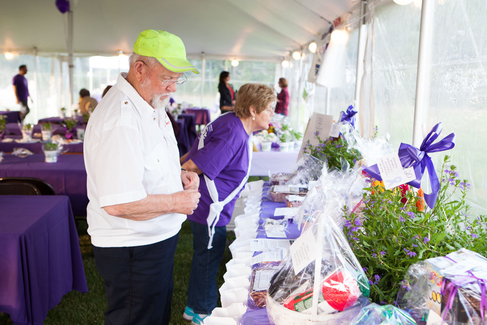 Bob Boergesson of Southold and wife Johanna, background, check out some of the many items in the auction. (Credit: Katharine Schroeder) 