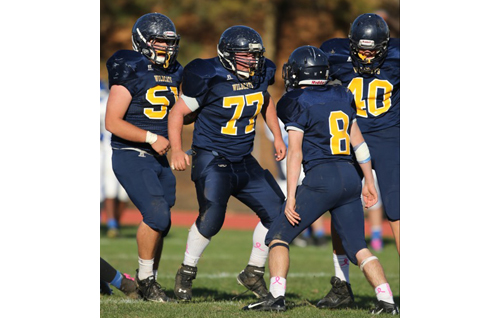 DANIEL DE MATO PHOTO | Shoreham-Wading River's Brennan Gorman (51), Max Goldfarb (77), Chris Rosati (8) and Ethan Wiederkehr (40) celebrate after stopping Elwood/John Glenn on a third-and-one play.