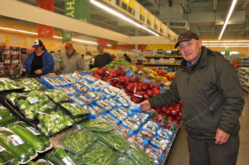 BARBARAELLEN KOCH PHOTO | A customer grabs some goods at the Aldi opening on Friday morning.