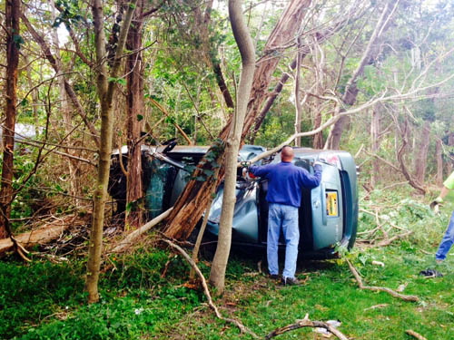 RACHEL YOUNG PHOTO | Tree branches around a Nissan Altima had to be cleared on Monday to get it out of the woods.