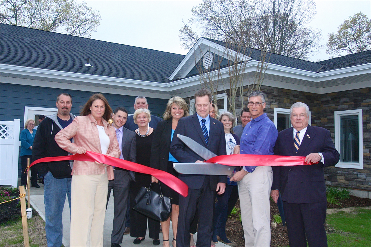 Brian Stark, president of Stark Homes, which operates Glenwood Village, cuts the ribbon with town officials outside the newly renovated and expanded 
