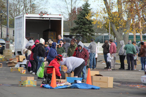 CARRIE MILLER PHOTO | About 150 people lined up beside the Peconic riverfront Friday afternoon to receive groceries from Lighthouse Mission.