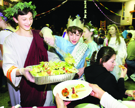 Riverhead Middle School seventh-graders Peter Cook (left) and Alex Bowe dish out salad at the schoolâs annual Roman banquet and play Thursday night. The banquet, held annually since 1997, featured various dishes prepared by parents and families of the middle school Latinists; the play written by students Bella Marcucci, Amy Methven and Liana Salgado.