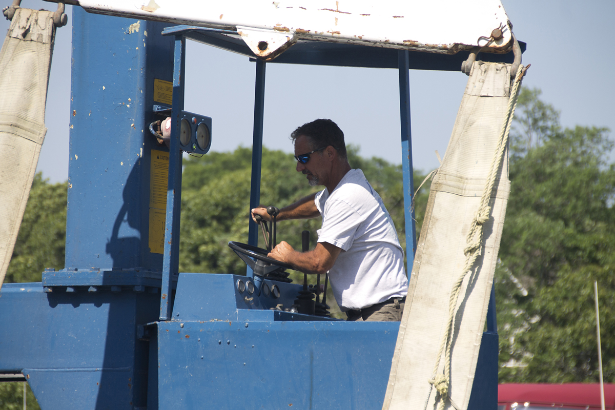 A Mattituck Inlet Marina employee operates the crane to lift Mr. Khan's plane from the water. (Credit: Paul Squire)