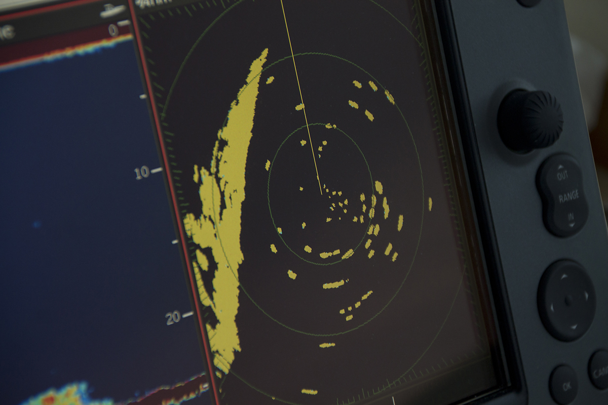 A radar screen aboard the auxiliary race committee boat shows the blips of competitors circling before the race begins. The shoreline is on the left. (Credit: Paul Squire)