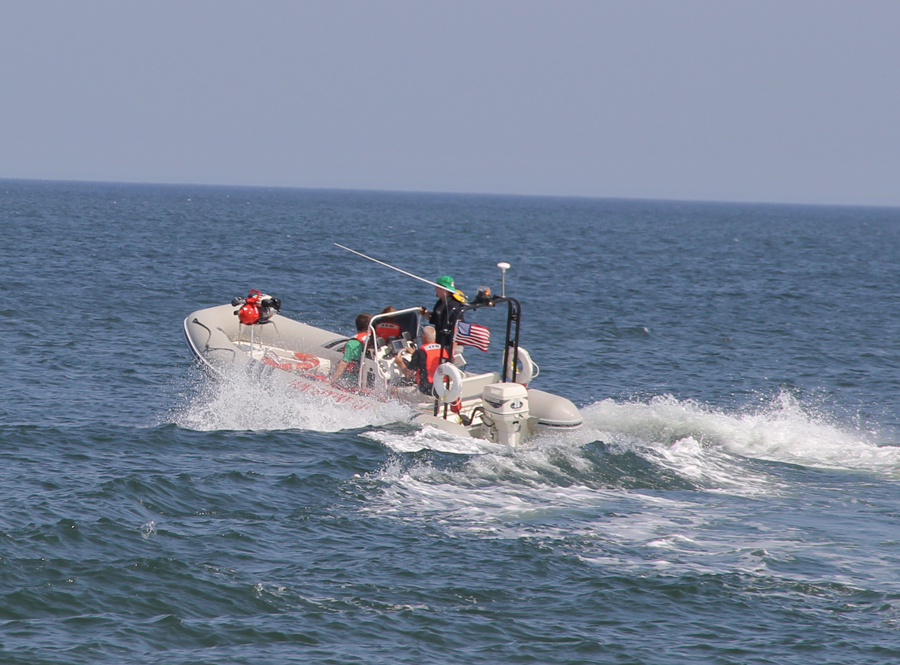 Jamesport firefighters launch a rescue boat from Iron Pier Beach during Monday morning's search and rescue efforts in the Long Island Sound. (Credit: Carrie Miller)
