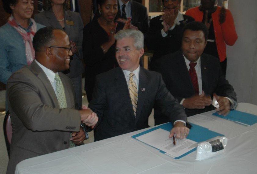 Suffolk County Legislature Presiding Officer DuWayne Gregory, left, and County Executive Steve Bellone shake hands after the law is signed. (Credit: Courtesy)
