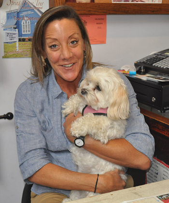 Groom+Gear owner Elissa Miles cuddles up with Lucy prior to the dog's grooming. (Credit: Cyndi Murray)
